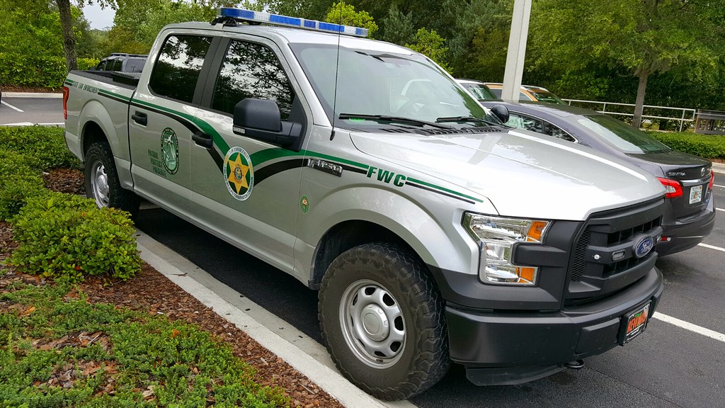 Image of a Florida Wildlife Commission game warden truck parked in a parking space. The 287(g) program allows local officers to detain and transfer people to ICE and wildlife agencies are participating directly.